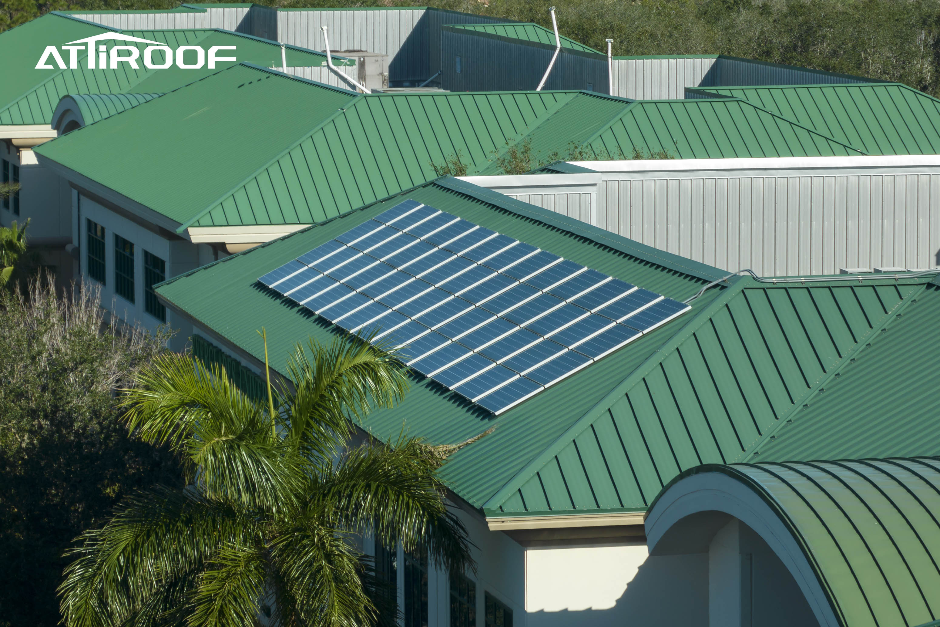 Tendencia moderna de techado que muestra tejas verdes de resina sintética integradas con paneles solares en un edificio comercial.