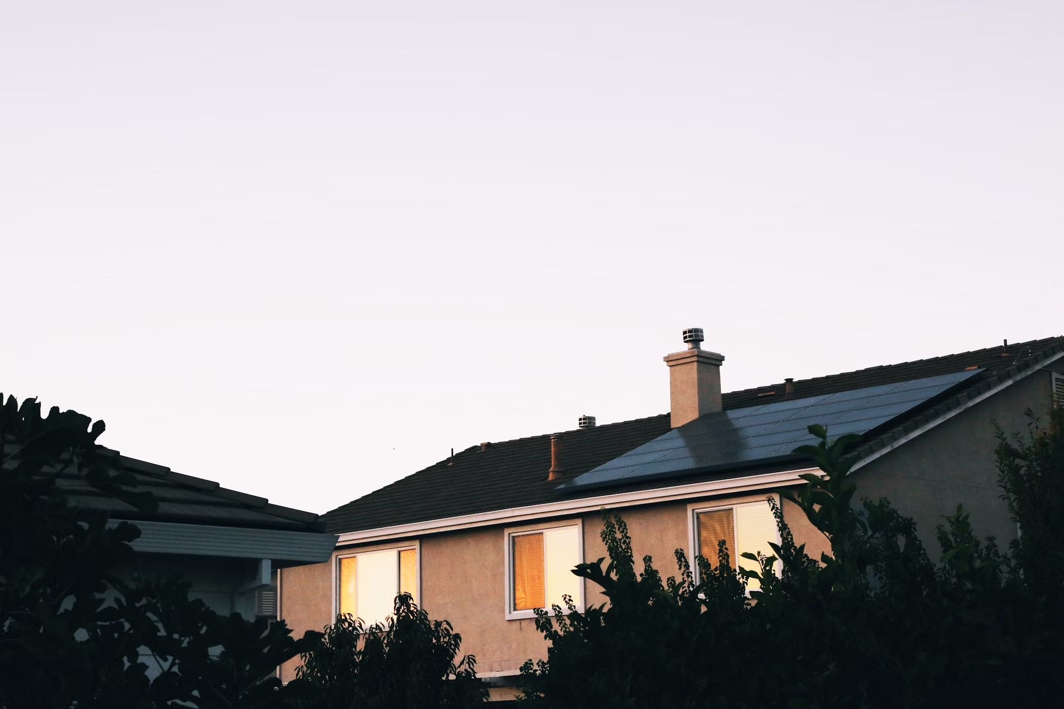 Una casa integra inteligentemente un sistema solar en su techo, con tejas y paneles solares perfectamente integrados, mostrando un concepto de estilo de vida ecológico y respetuoso con el medio ambiente.