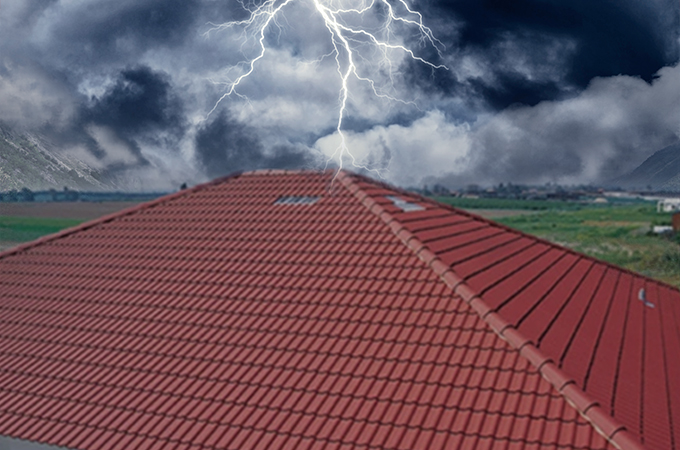 Techo de tejas rojas que soporta una tormenta, mostrando durabilidad y resistencia a la intemperie en condiciones extremas.