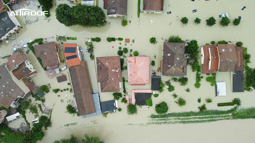 Vista aérea de casas inundadas, que muestra la resistencia de los techos metálicos revestidos de piedra de Atiroof en condiciones climáticas extremas y con fuertes vientos.