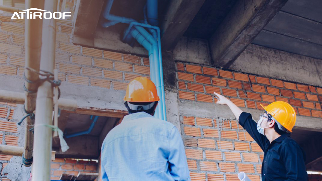Imagen de una discusión con contratistas de techado sobre los términos de la garantía en un sitio de construcción.
